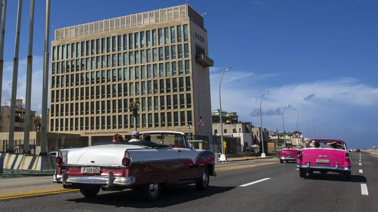 A car driving beside the United States Embassy in Havana, Cuba.