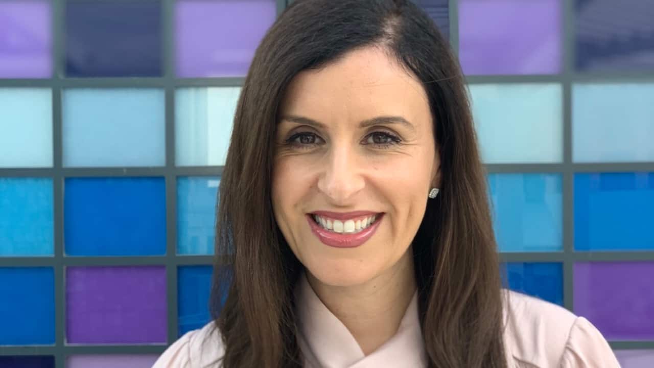 A woman smiling as she poses for a photo.