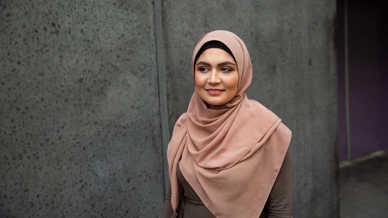 Portrait of a smiling young woman wearing hijab on street