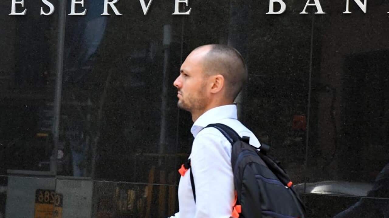 A pedestrian walks past the Reserve Bank of Australia in Sydney,