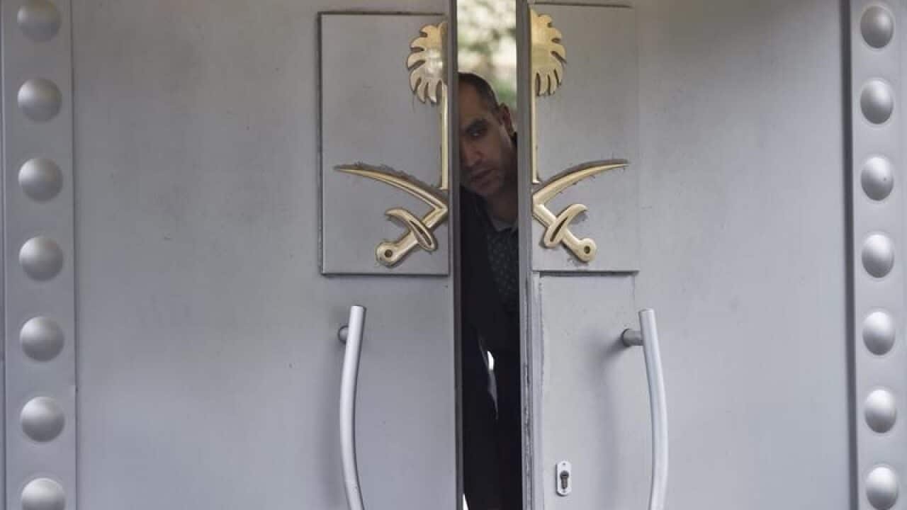 A security personnel peeps from the doors of the Saudi Arabia consul