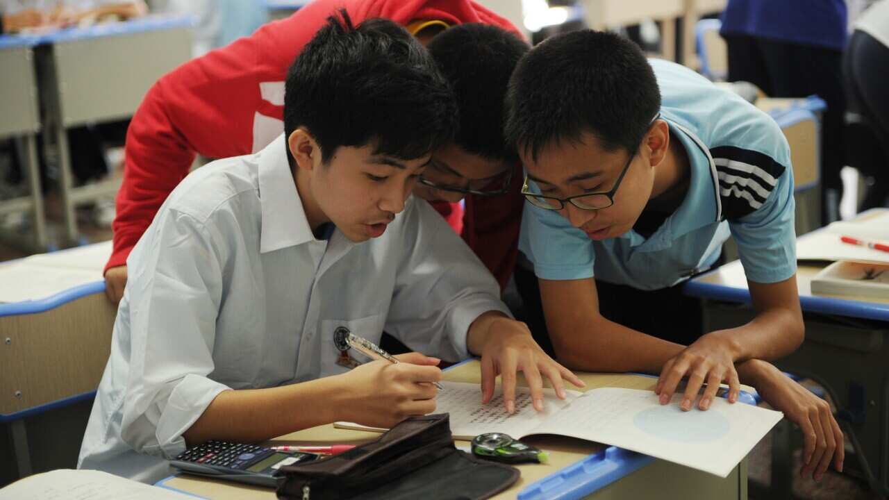 Chinese schoolboys solving a math problem