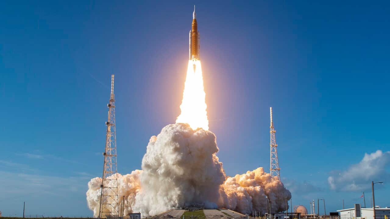 A spaceship lifts off from a launchpad leaving exhaust fumes behind