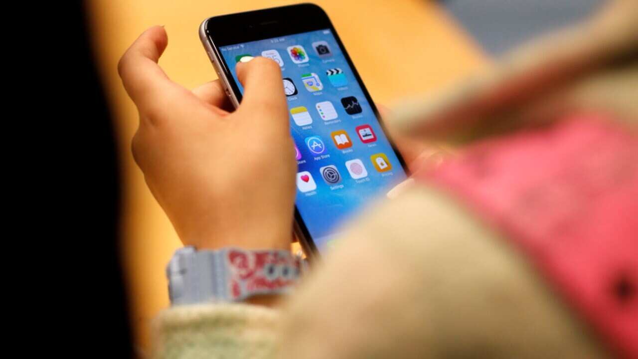 A child playing with an iPhone 6S at an Apple store