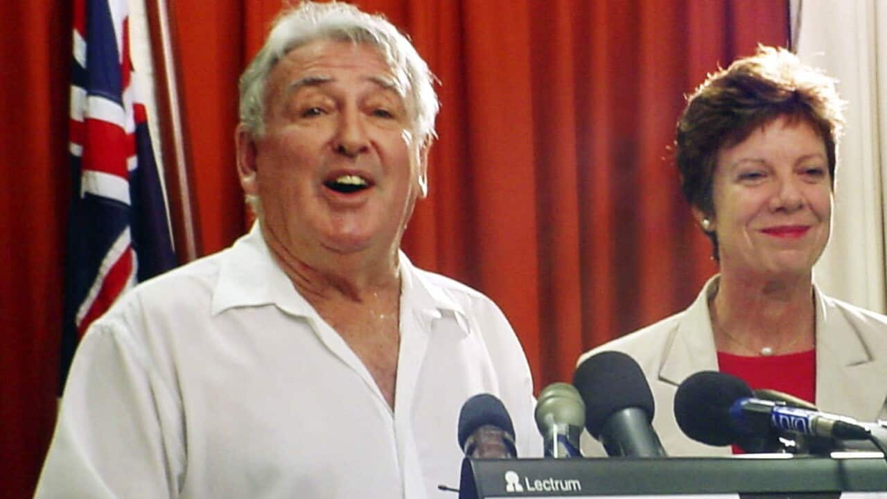 A man in a white collared shirt speaks at a lectern with the words 'THE NORTHERN TERRITORY' on it