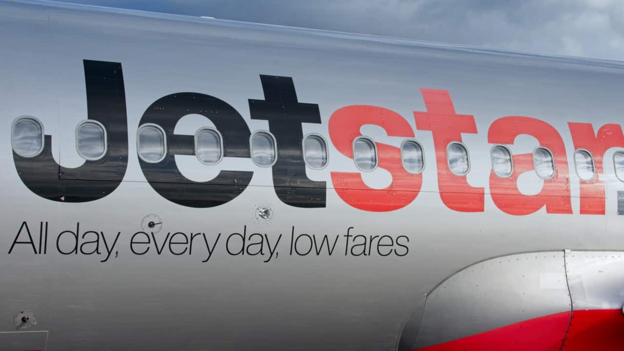 Closeup view of a Jetstar passenger plane with trademark logo sign.