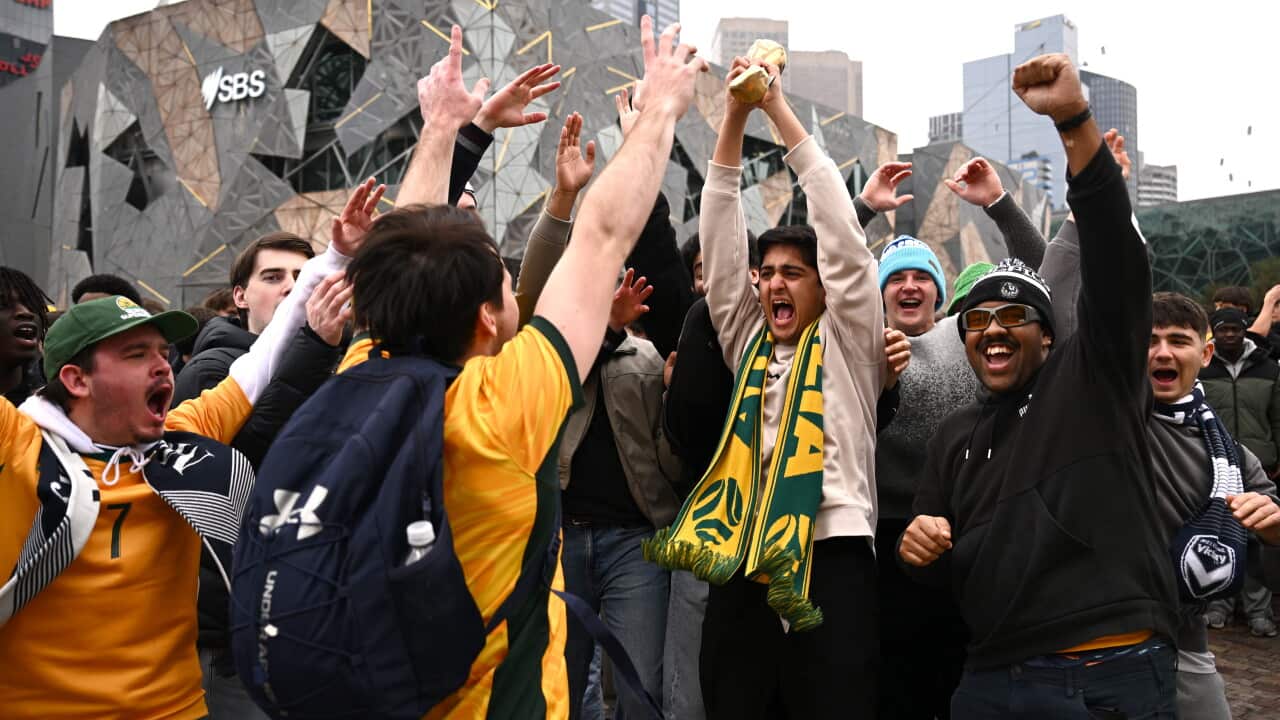 Australian fans celebrate in front of the Melbourne skyline at Federation Square