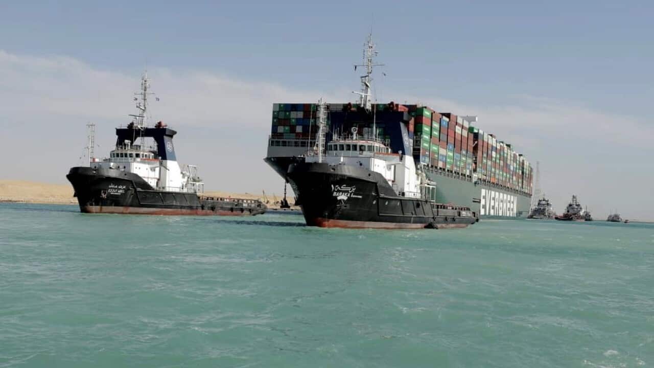 Tugboats near the Ever Given container ship after it was refloated in the Suez Canal.