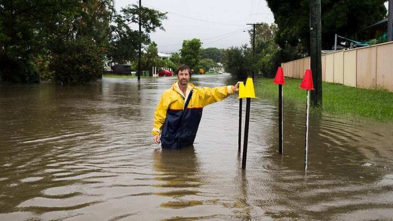 Local resident Paul Shafer standing in floodwaters in Hermit Park Townsville. (AAP)