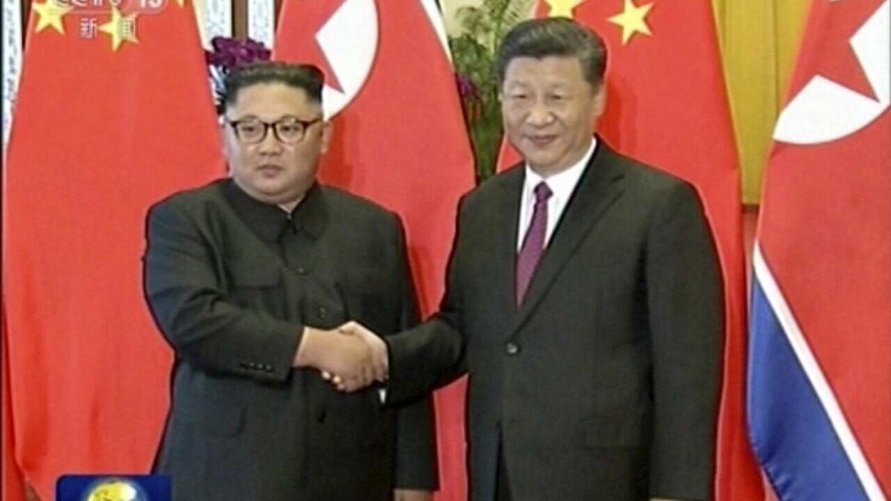 Chinese President Xi Jinping stands next to North Korean leader Kim Jong-un on Tuesday.
