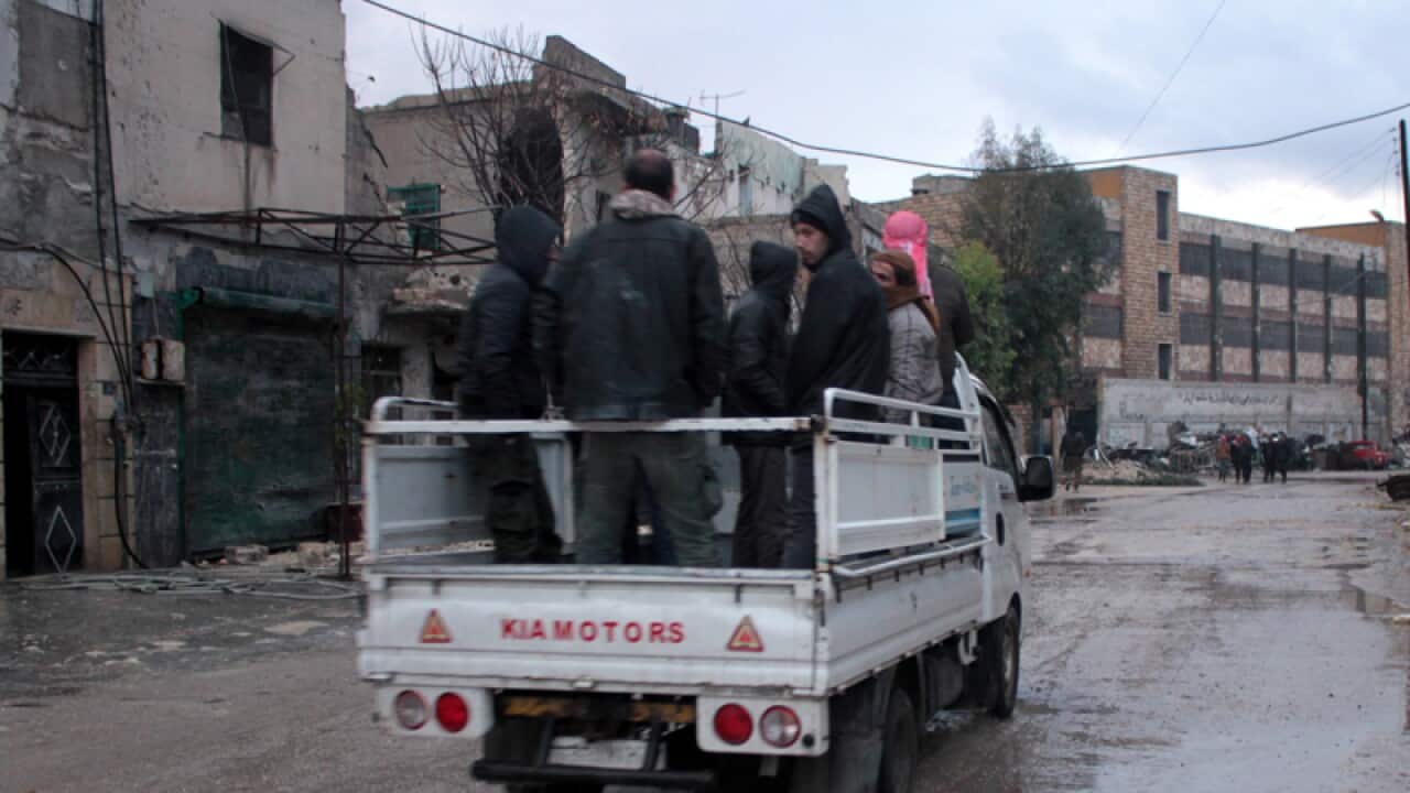 People ride in a truck in the rebel-held part of Aleppo