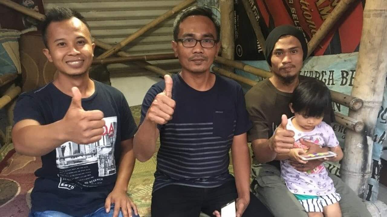 (L-R) Ahmad Azhar, cafe owner Muhammad In'am and Salman al-Faluty