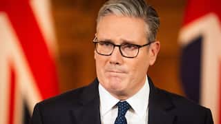 A middle-aged white man with glasses and a suit frowning