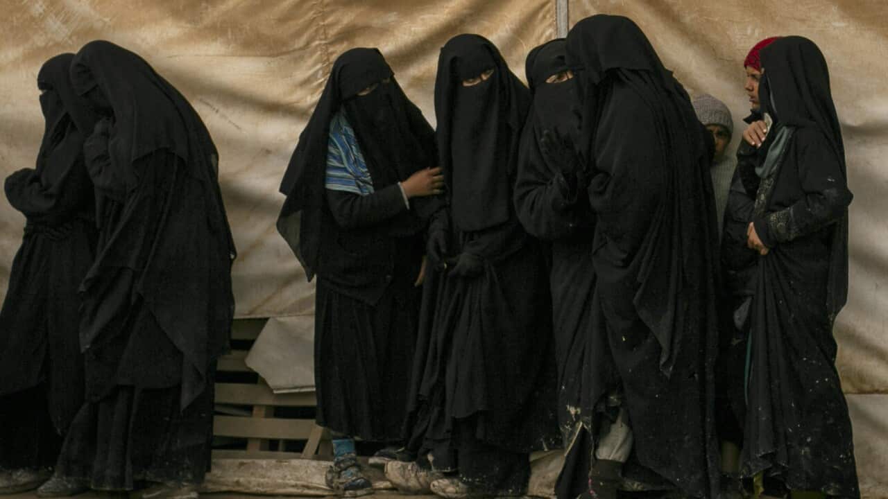 Women queue for aid supplies at al-Hol camp, home to Islamic State-affiliated families.