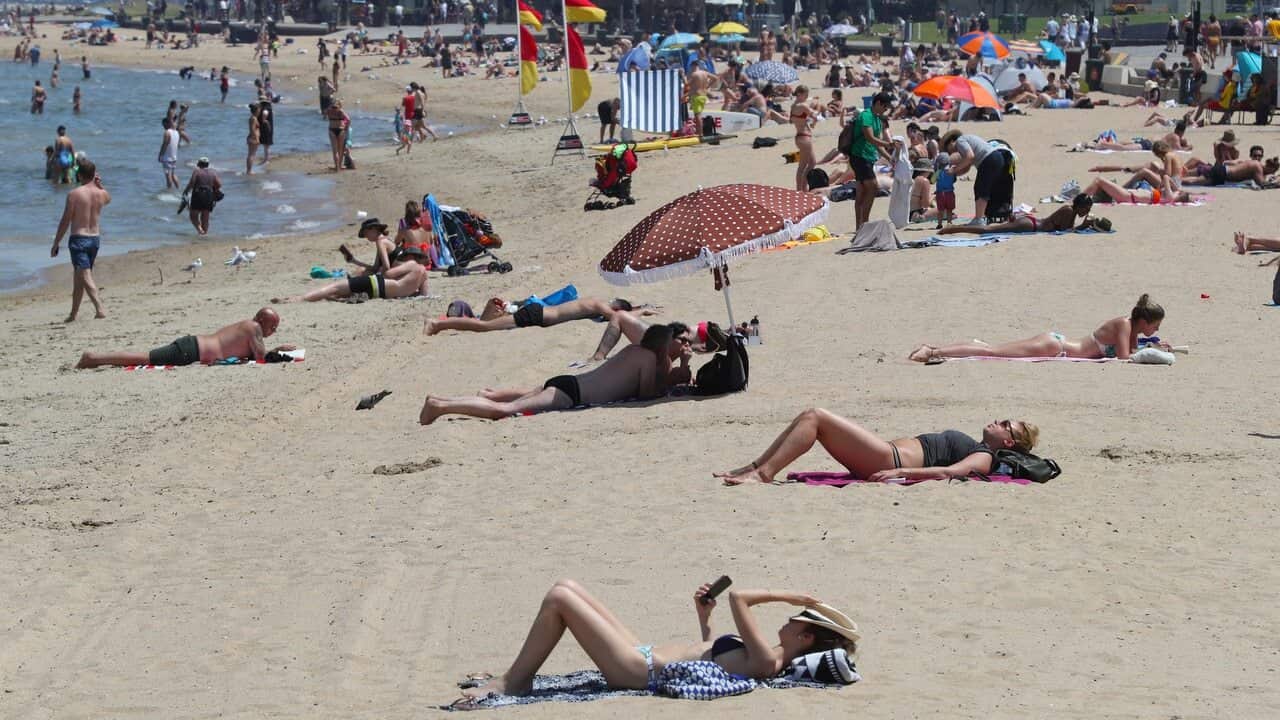 Beachgoers are seen during a hot day at St Kilda beach in Melbourne on 27 December 2018.