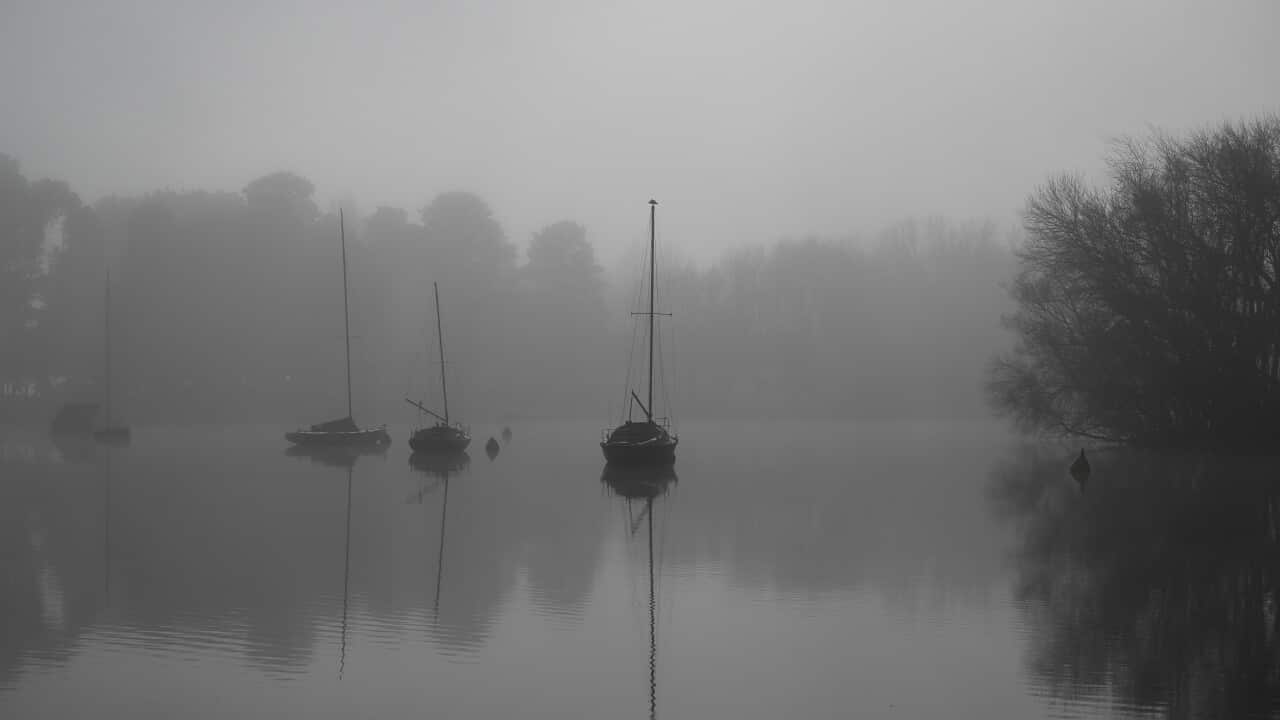 Boats on a lake on a grey, foggy day