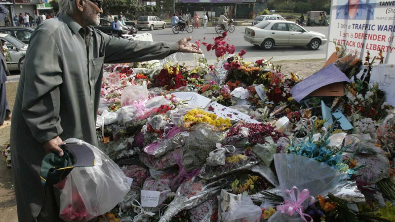 A Pakistani man places flowers at the scene of an attack in 2009