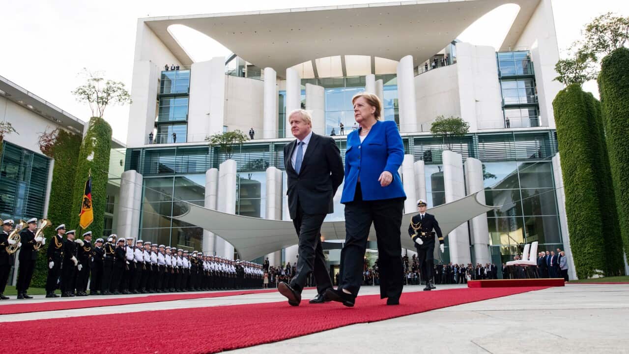 Germany's Angela Merkel and Britain's Boris Johnson walk the red carpet during a welcome ceremony in Berlin