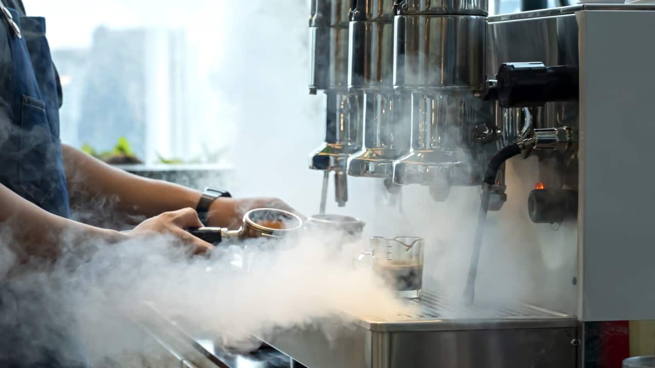 A barista working at a coffee machine.