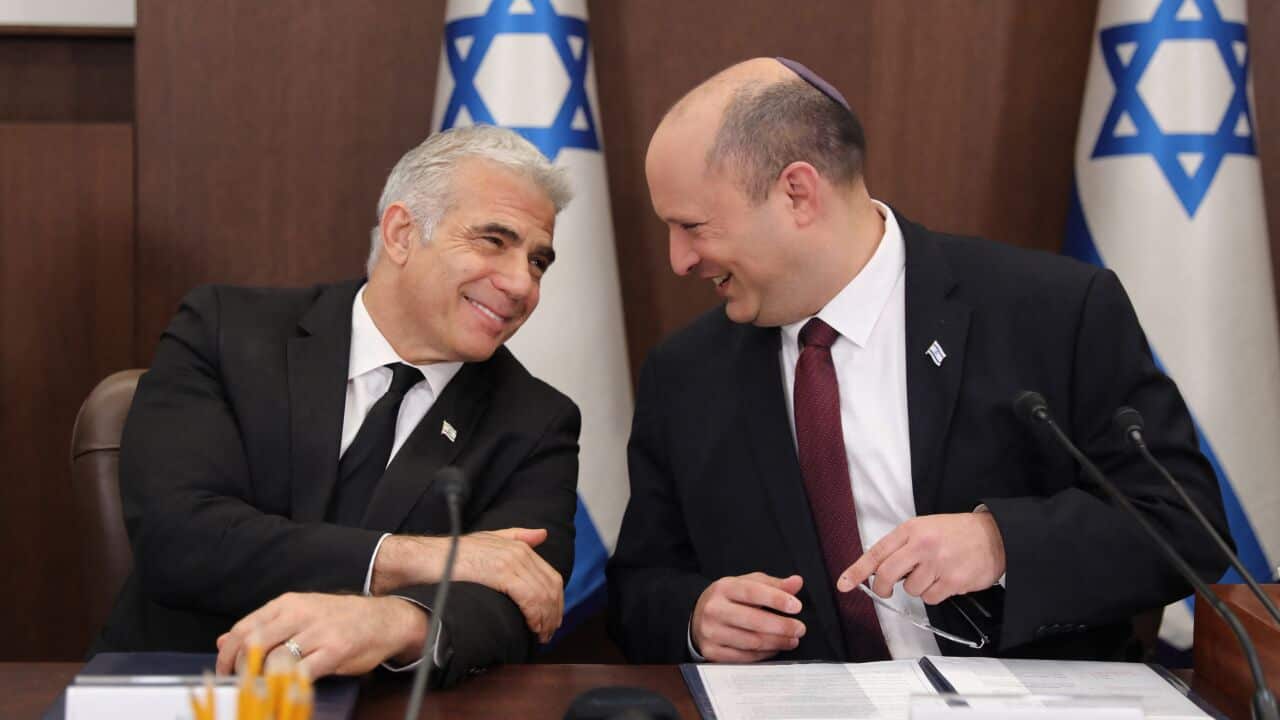 Israeli Prime Minister Naftali Bennett (right) speaks with Foreign Minister Yair Lapid (left) during a cabinet meeting in Jerusalem on 19 June 2022.