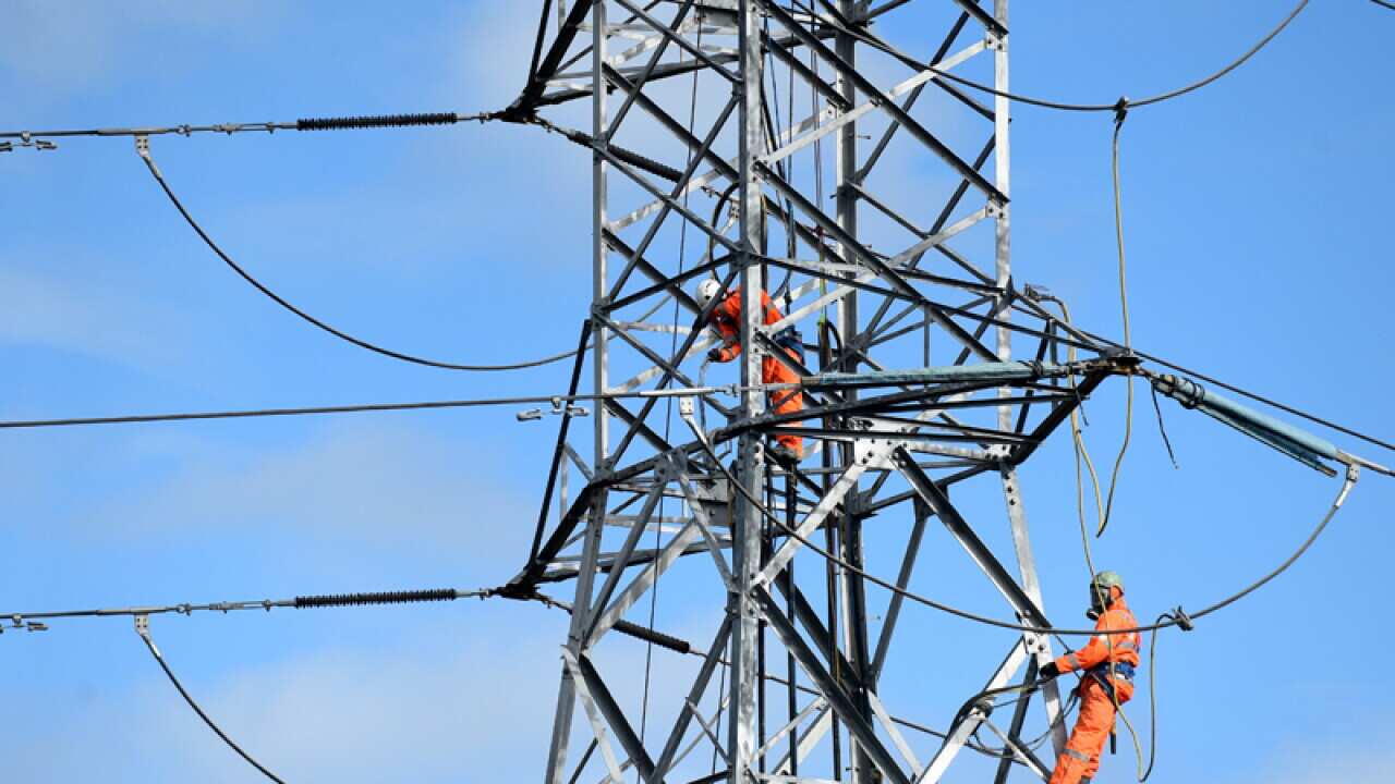 Workers on a high tension electricity pylon