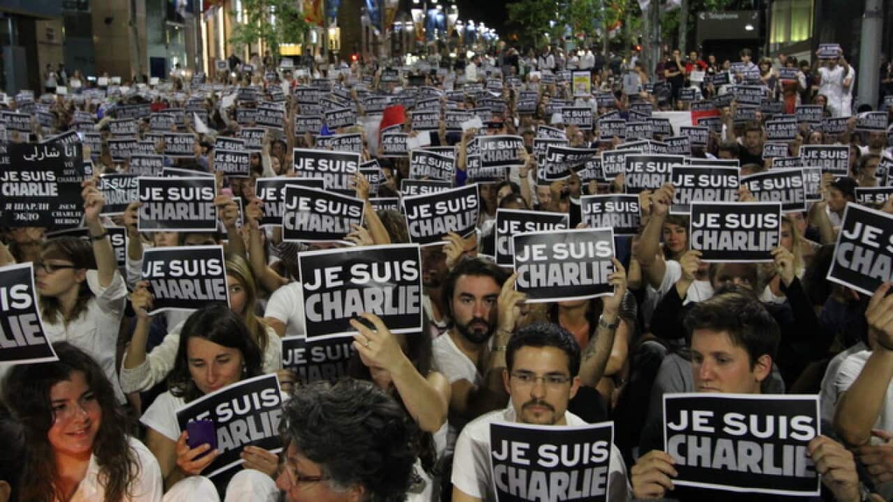 Demonstrators hold up 'Ju suis Charlie' placards at Sydney's Martin Place on January 8, 2015, during a vigil held to show support for the victims of the attack on the office of satirical magazine Charlie Hebdo in Paris. (AAP Image/NEWZULU/PETER BOYLE).