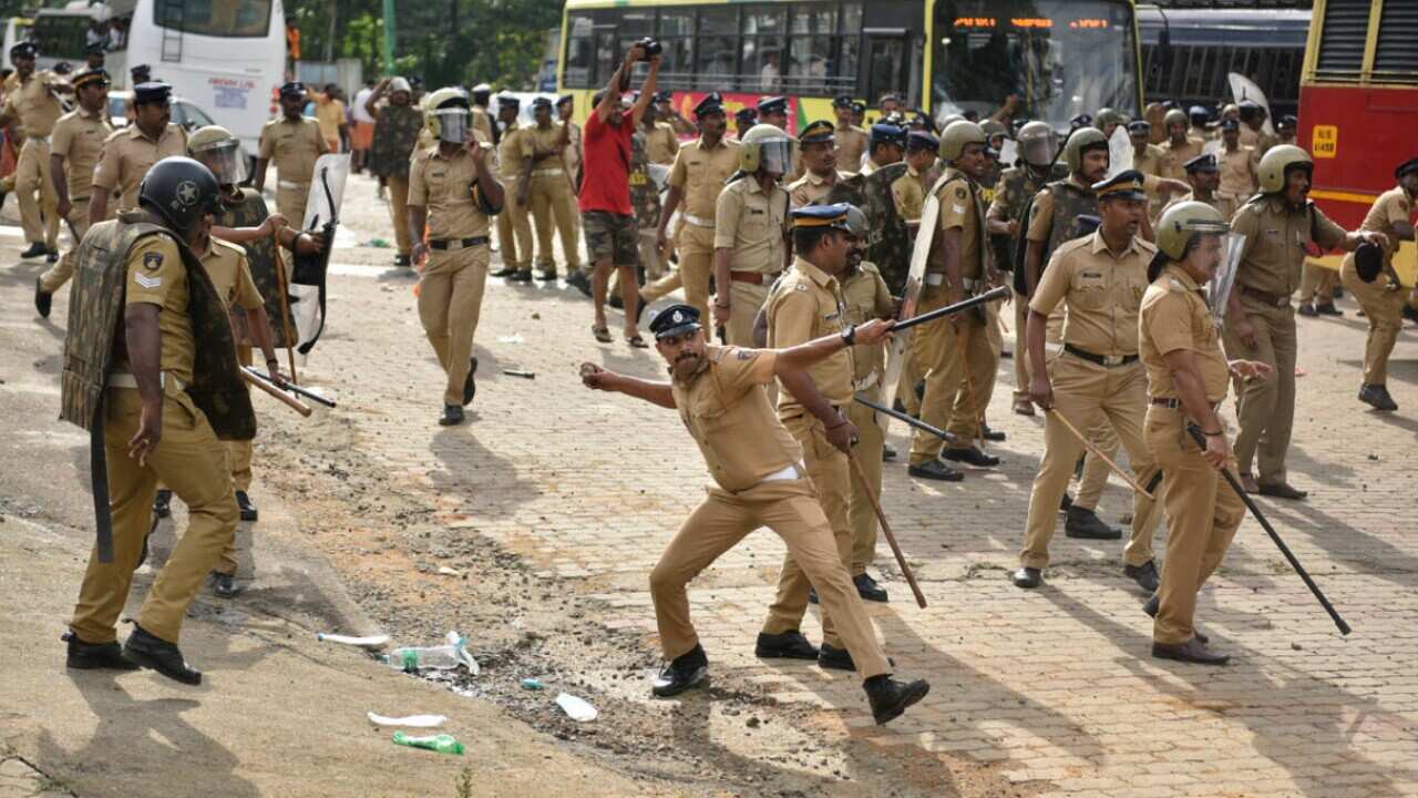 A policeman throws back a stone as they clash with protestors