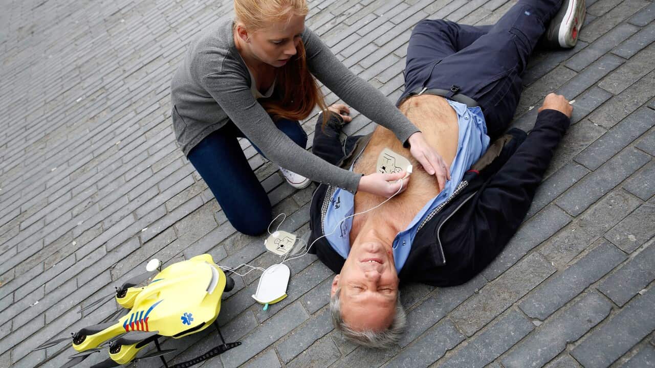 A woman gives a demonstration of an ambulance drone with built in defibrillator at the campus of the Delft Technical University in Delft, The Netherlands, 28 October 2014. (EPA/BAS CZERWINSKI)