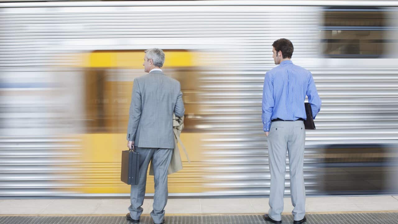 Businessmen watching speeding train