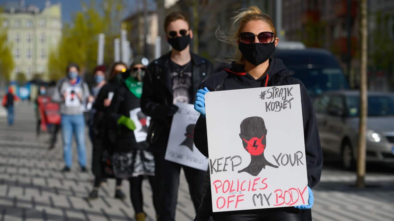 Protesters stand 1.5 metres apart whilst holding placards protesting the issue of Poland's restrictive abortion ban.