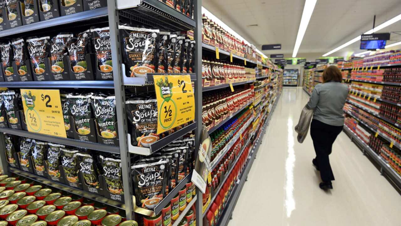 A stock image of a woman walking through a product isle