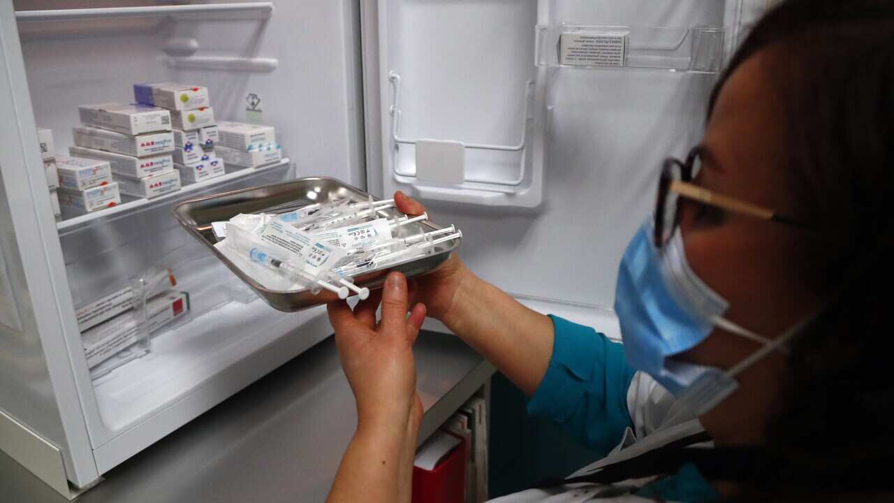 A nurse takes a dose of the Pfizer-BioNTech COVID-19 vaccine from a fridge in Montpellier, France 19 January 2021.