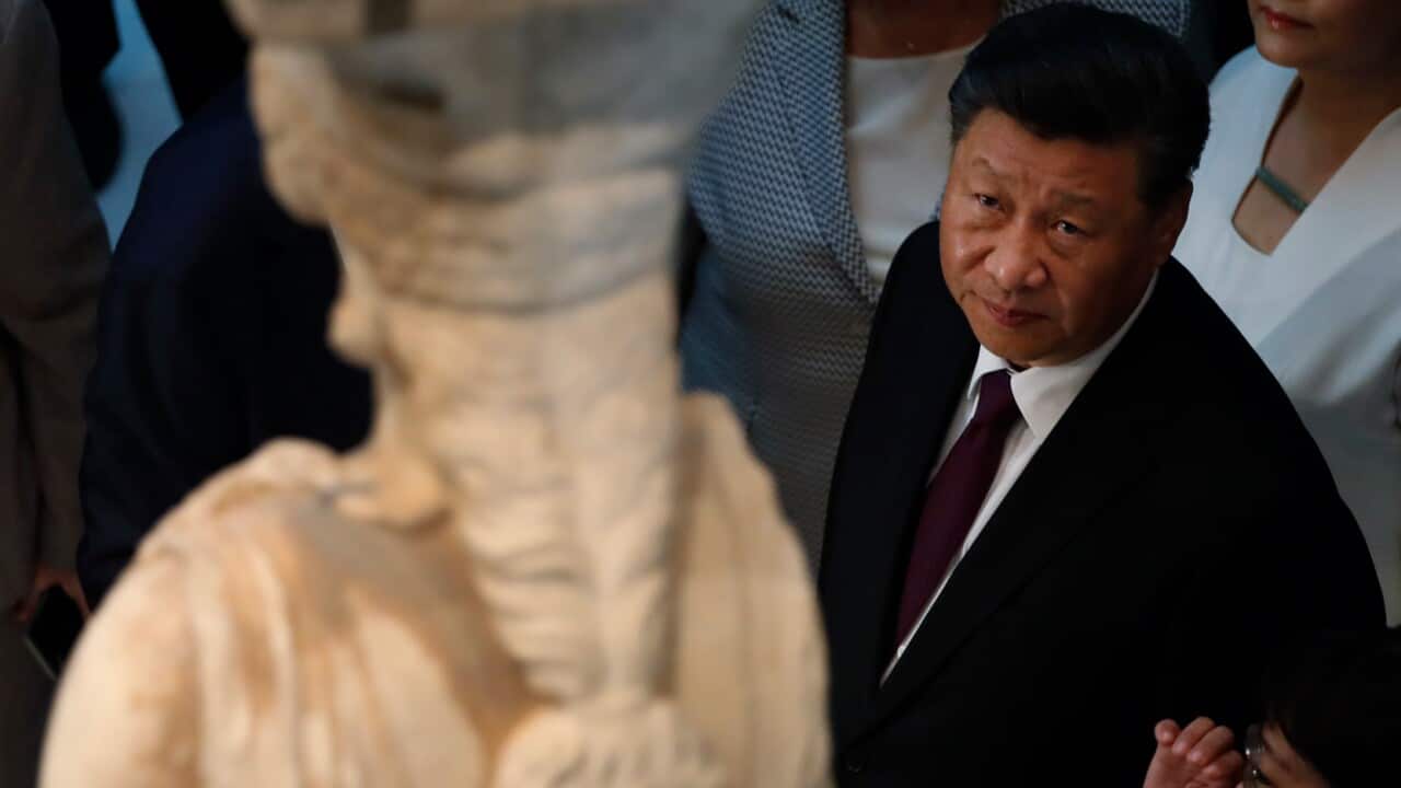 China's President Xi Jinping looks at a 2,500-year-old Caryatid statue, during a visit at the Acropolis Museum