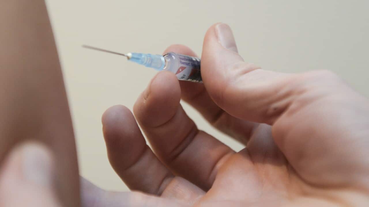 A doctor injects a vaccine