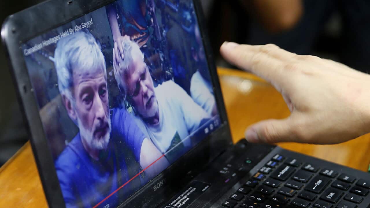 An armed forces spokesman watches a video of four kidnapped people