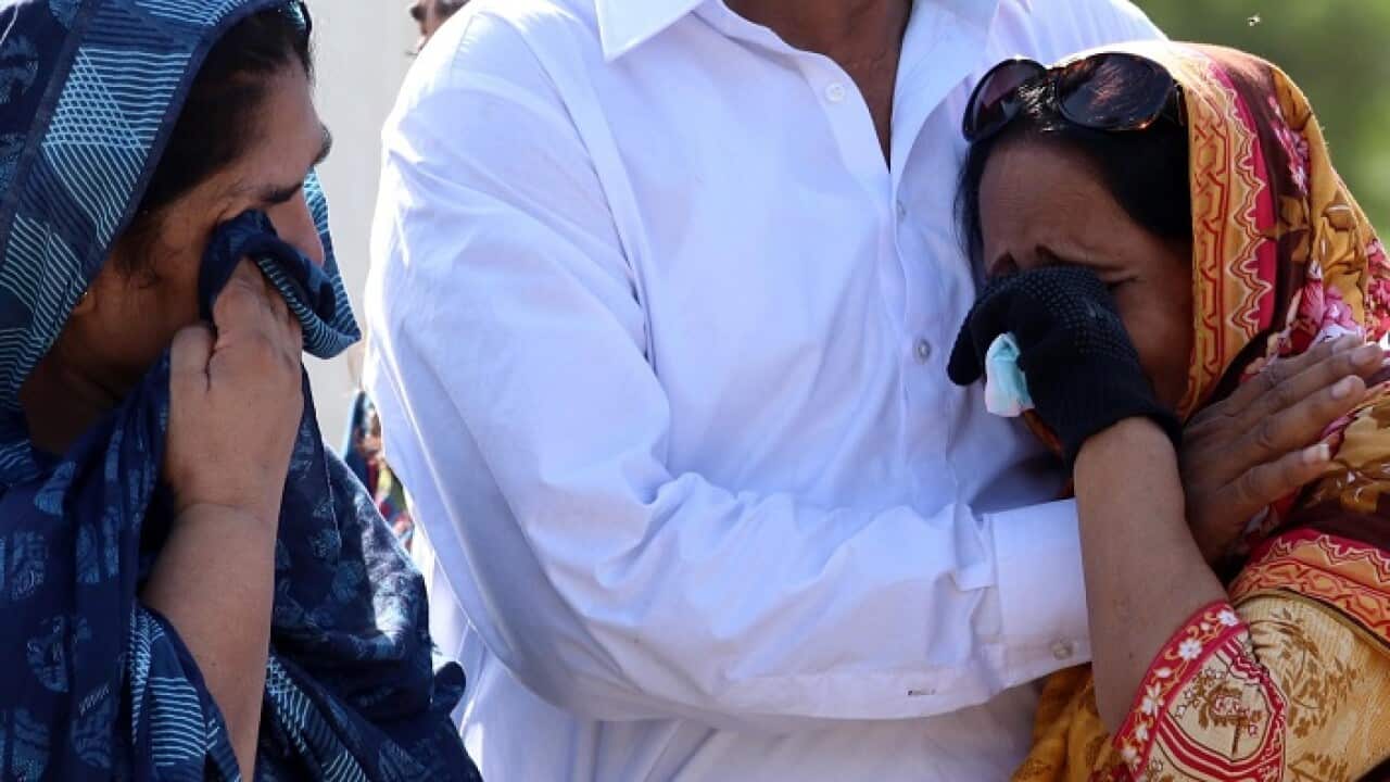 Relatives attend the funeral of a victim of a plane crash in Karachi, Pakistan, 25 May 2020.