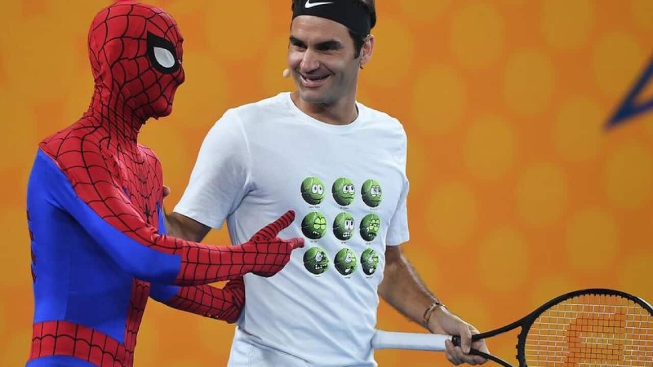 Roger Federer is seen alongside a person dressed as Spiderman