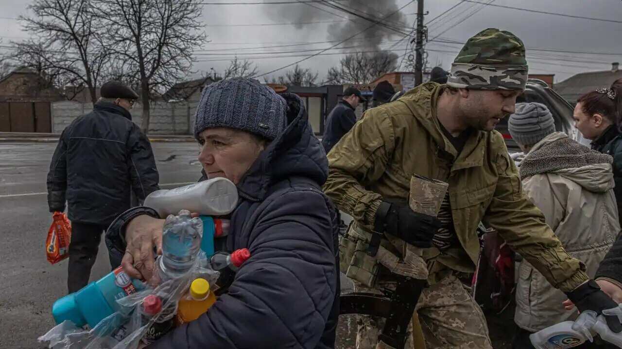 An elderly woman receives water and cleaning products distributed by Ukrainian military members to local residents, in Irpin city, Ukraine, on 3 March 2022.