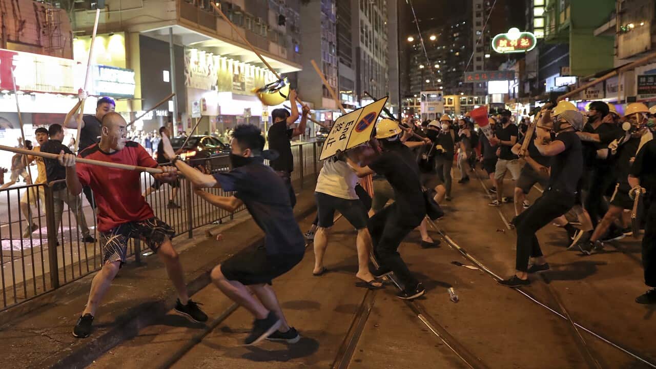 Protesters fight with a group of men wielding wooden poles on a Hong Kong street.