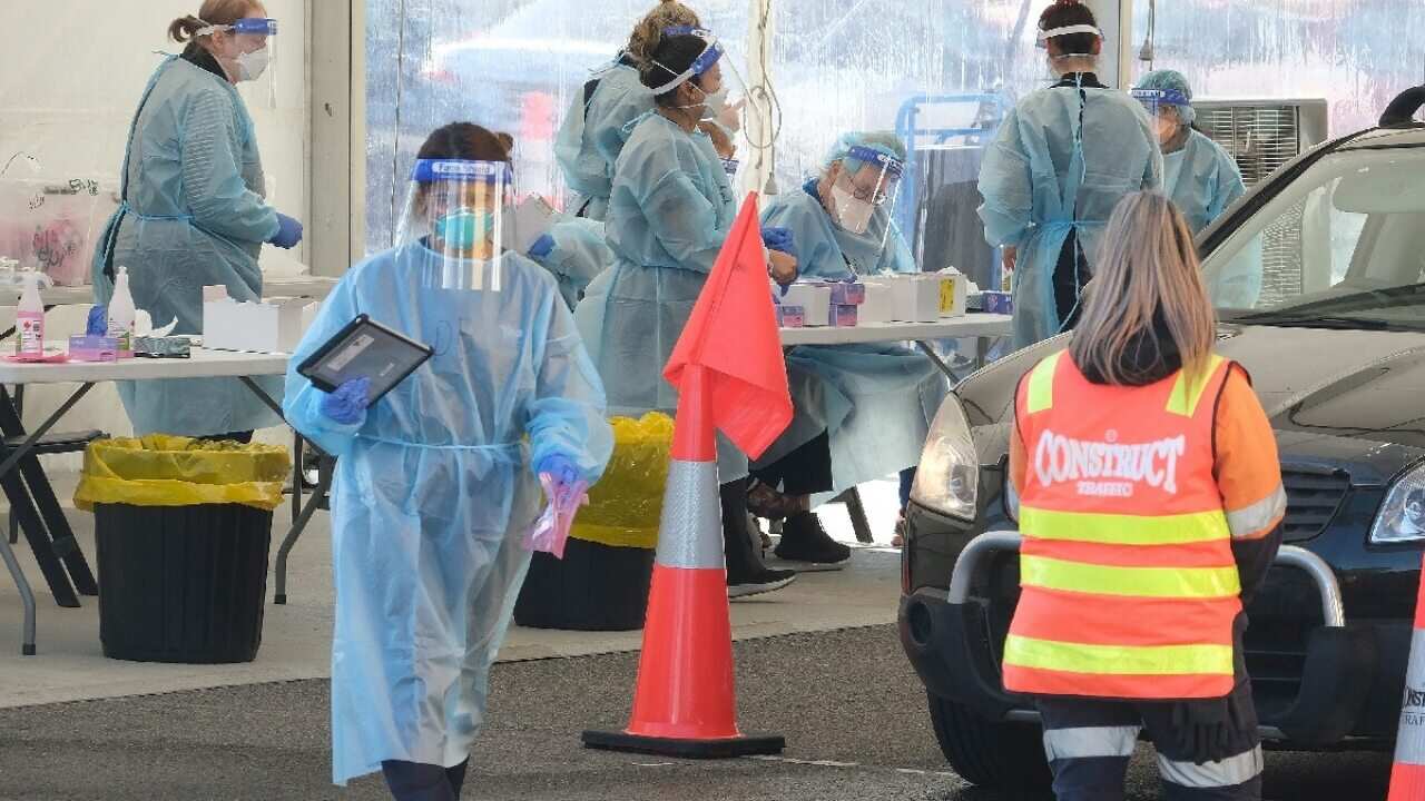 Health workers perform COVID-19 tests in the pop-up testing site outside the Palais Theatre in St Kilda, Melbourne on 20 August 2021.