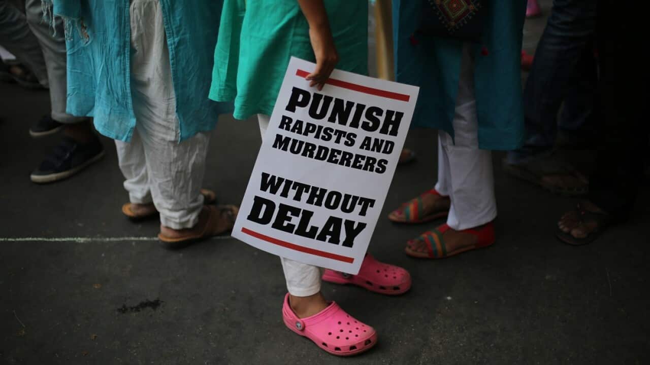 An Indian protester stands with a placard during a protest after recently reported rape cases. 
