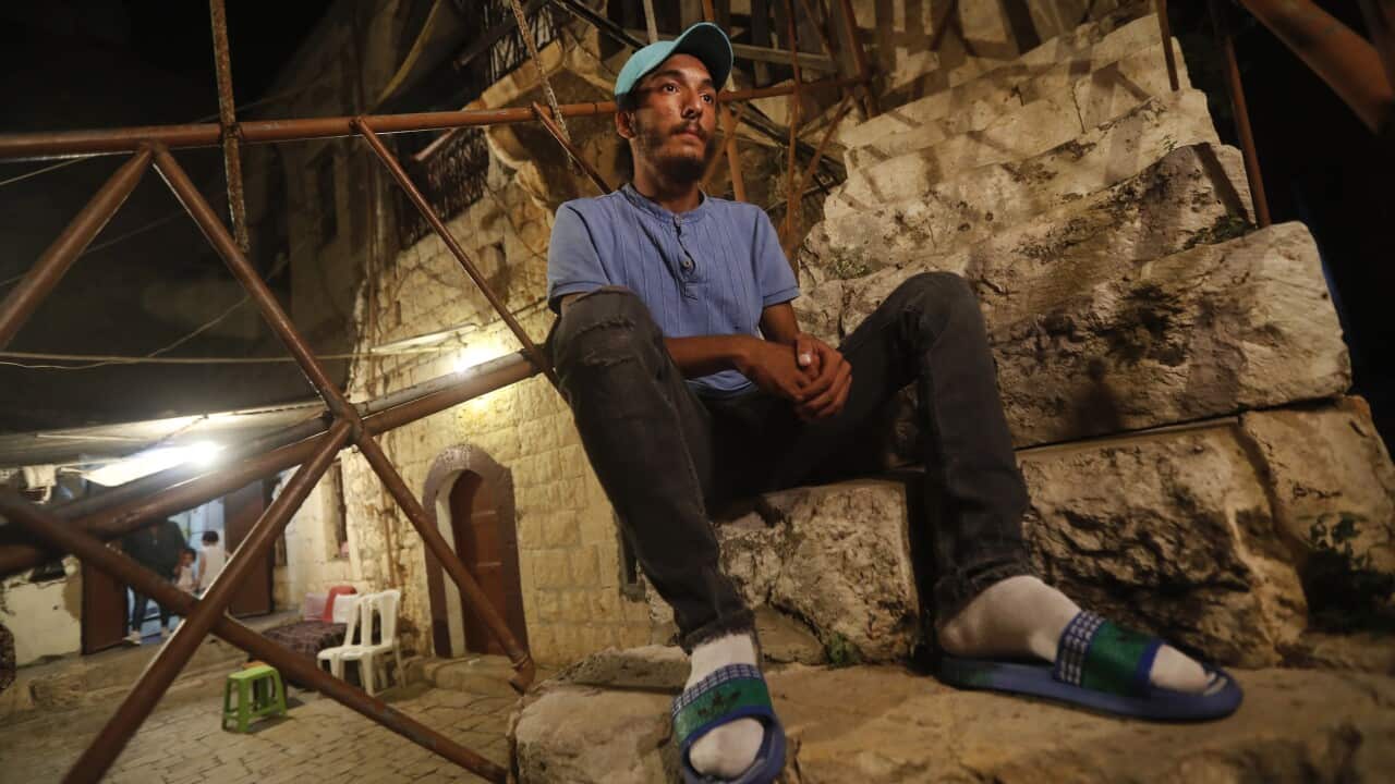 Mohammed Sufian sits outside his house in Tripoli after being rescued at sea while trying to migrate with his family to Cyprus. His son died on the journey.