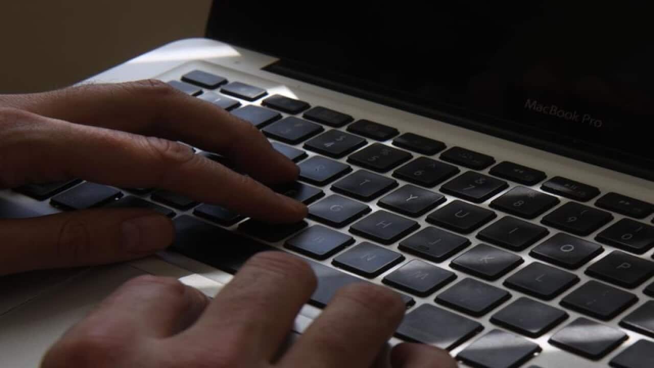 Fingers typing on a laptop