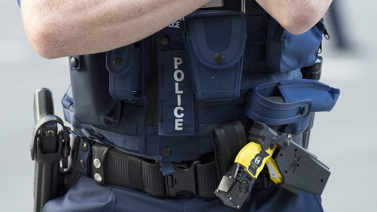 Photograph of a Queensland Police Officer wearing a Taser and a hand gun.