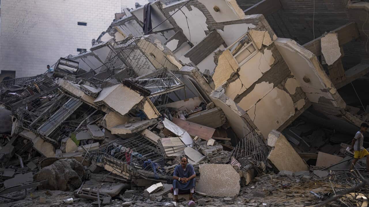A man sits in the rubble of a building after it was struck by an Israeli airstrike.