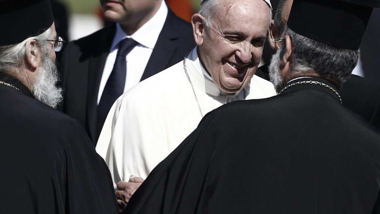 Pope Francis (C) greets Greek Orthodox bishops at the island Lesvos