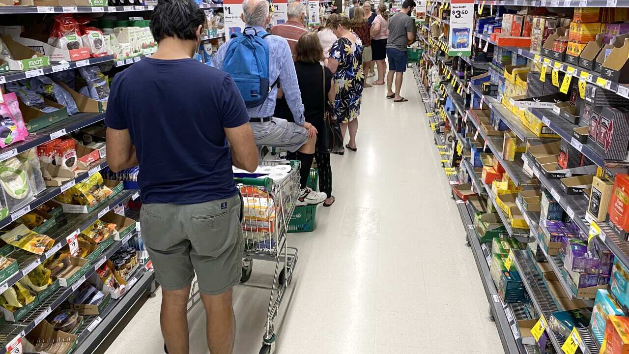 People are seen lined up waiting to go through the checkout inside Woolworths at Mt Gravatt in Brisbane on 8 January ahead of a three-day lockdown.