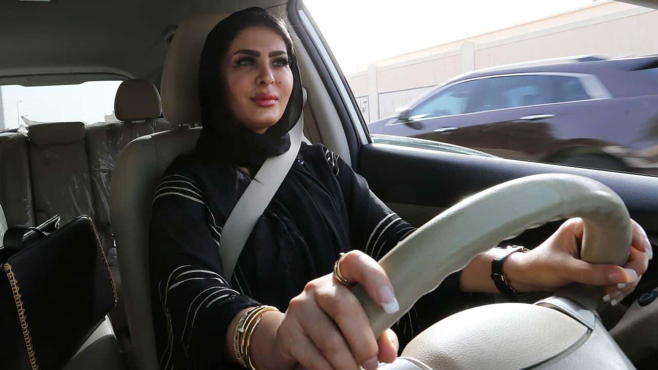 Huda al-Badri, 30, poses behind a steering wheel of a car in the early morning hours when the royal decree lifted ban on women driving a car in Saudi Arabia.