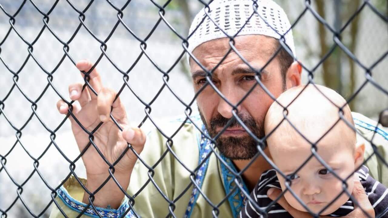 Muslim refugee holding his baby