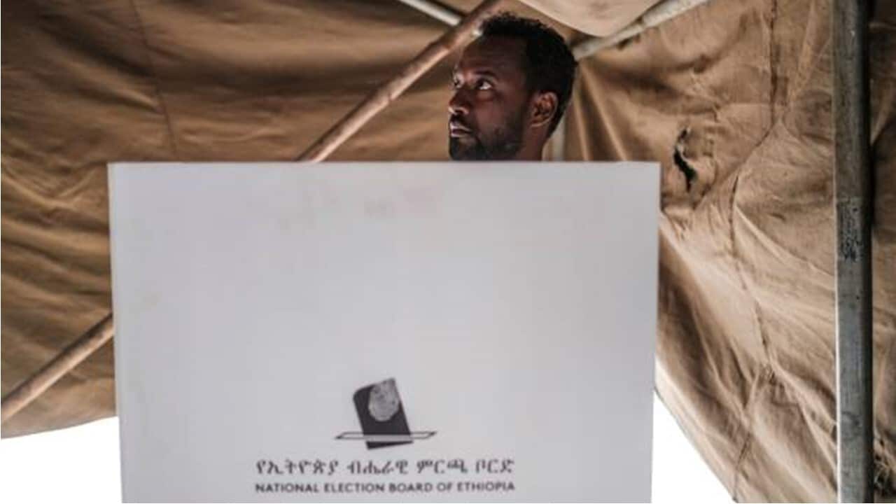 A man prepares his ballot in a polling booth at a polling station in the city of Bahir Dar, Ethiopia.jpg